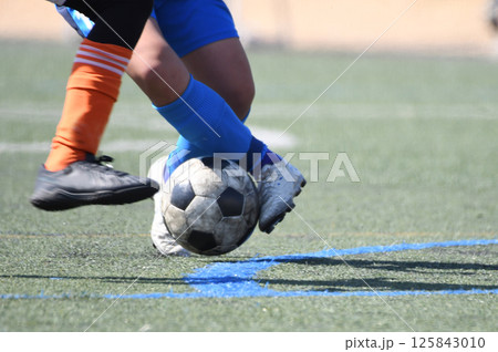 ドリブルするサッカー選手 125843010