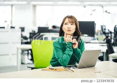 オフィスで悩むキャリアウーマン オフィスで悩むキャリアウーマン 125843638