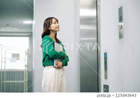 エレベーターが来るのを待つ女性 125843643