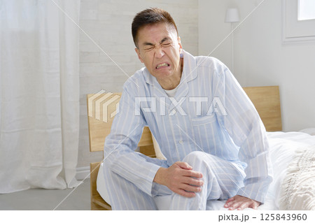 膝が痛いパジャマを着た中年の男性 125843960