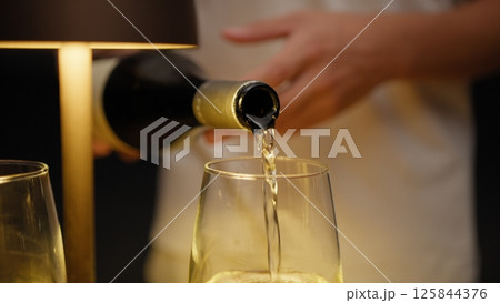 Waiter Pouring Expensive Wine Into The Glasses For The Customers Waiter Pouring Expensive Wine Into The Glasses For The Customers 125844376