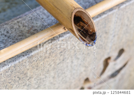 【日本】東京都北区の王子神社の手水舎の竹から水が滴り落ちる 125844681