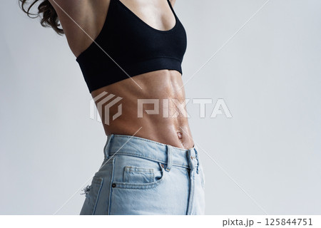 Close-up of a woman's perfect body with abs demonstrating weight loss, slimming. Close-up of a woman's perfect body with abs demonstrating weight loss, slimming. 125844751