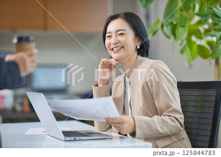 オフィスで打ち合わせをするミドル女性 125844783