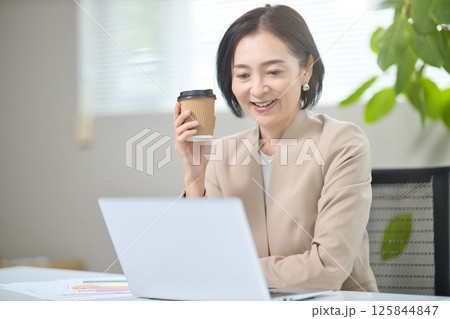 オフィスで打ち合わせをするミドル女性 125844847