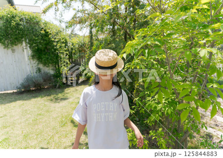 麦わら帽子で顔を隠す女の子 125844883