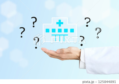 病院のアイコンとクエスションマークを掲げるドクターの手 病院のアイコンとクエスションマークを掲げるドクターの手 125844891
