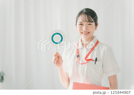 マルバツ札のマルを挙げる若手看護師 マルバツ札のマルを挙げる若手看護師 125844907