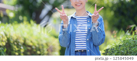 ピースする笑顔の女性 ピースする笑顔の女性 125845049