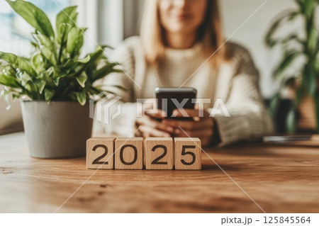 Minimalist Office Desk with Plant and Wooden Blocks displaying 2025 125845564