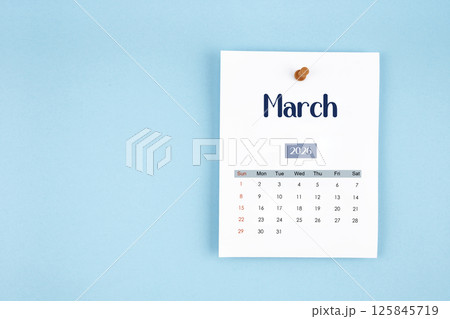 March 2026 calendar page with push pin on blue background. 125845719