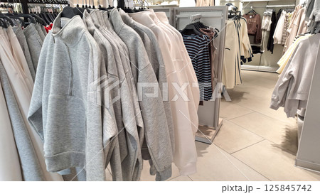 Casual clothing display with hoodies, sweaters, and coats in a retail store Casual clothing display with hoodies, sweaters, and coats in a retail store 125845742