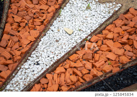 Geometric garden path with red and white stones 125845834