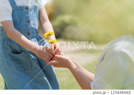 たんぽぽを手渡す女の子 125846068