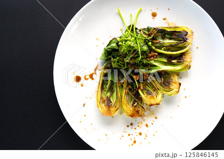 Grilled bok choy with fresh herbs on a contrasting plate for an elegant touch. 125846145