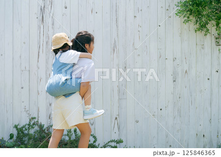 妹をおんぶする女の子 125846365
