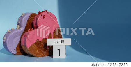 Calendar date 1 June International children's day greeting card Delicious fresh croissant topped with colorful flavor Ganache. Creation unique heart shape bakery. Puff pastry holiday love gift present 125847253