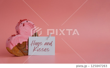 Birthday Valentine's day HUGS AND KISSES wishes saying caption on greeting card Delightful heartshaped pastry croissant treat, beautifully topped with colorful frosting galore. Copy space. Food 125847263