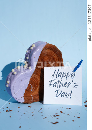 Happy Father's Day saying caption on greeting card Delicious fresh croissant topped with colorful flavor Ganache. Creation unique heart shape bakery. Puff pastry holiday love gift present idea 125847307