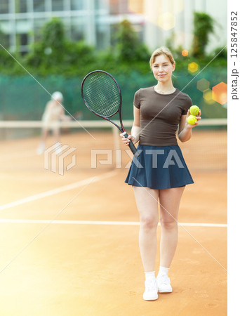 Young woman posing on tennis court Young woman posing on tennis court 125847852