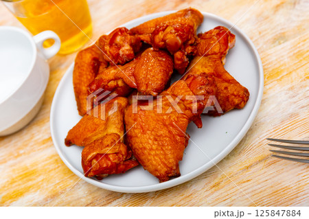 Crispy smoked chicken wings served in a flat plate Crispy smoked chicken wings served in a flat plate 125847884
