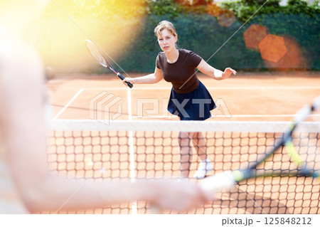 Young woman plays tennis on tennis court Young woman plays tennis on tennis court 125848212