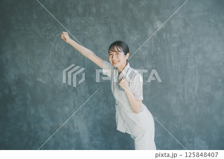 拳を突き上げる若手看護師 125848407