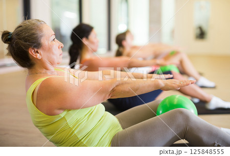 Women doing crunhces with pilates balls Women doing crunhces with pilates balls 125848555