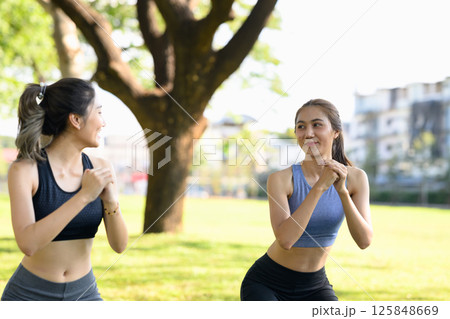 Fit Asian women in sportswear working out together in nature 125848669