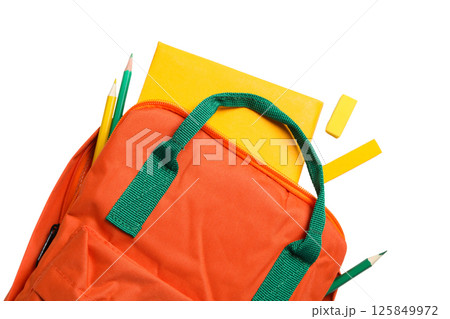 Bright orange backpack with school supplies on a white surface, isolated on white 125849972