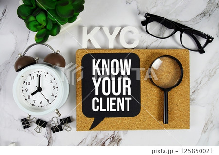 KYC - Know Your Client acronym with alarm clock and magnifying glass, business concept background 125850021