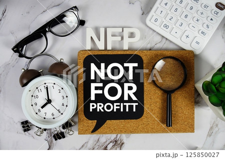 NFP - Not For Profit acronym with calculator, alarm clock and magnifying glass, business concept background 125850027