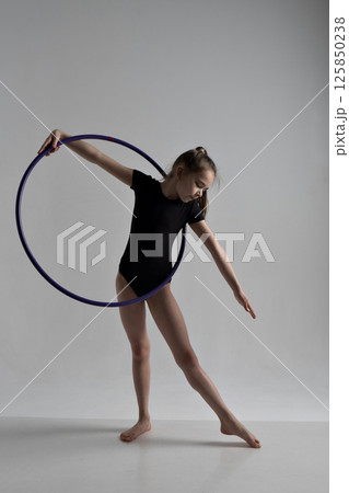 A girl in a swimsuit and a dress shows beautiful athletic elements on a white background. Ballet, rhythmic gymnastics, fabric, aesthetics, grace. High quality photo 125850238