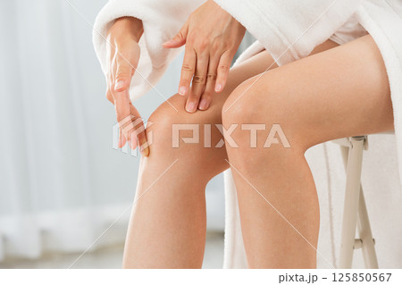 アジア人の若い女性は膝のスキンケアをしています。 125850567