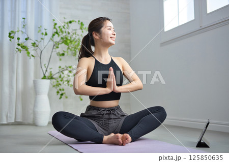 オンラインヨガを楽しむ20代の女性 125850635