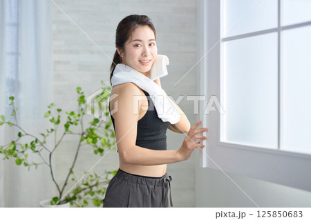 タオルで汗を拭くヨガウェアの20代女性 タオルで汗を拭くヨガウェアの20代女性 125850683
