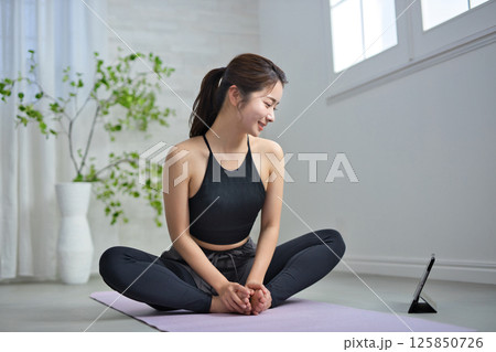 オンラインヨガを楽しむ20代の女性 125850726