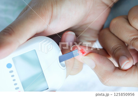 hand of people check diabetes and high blood glucose monitor with digital pressure gauge. Healthcare and Medical concept 125850956