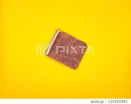Fashionable brown men's leather wallet isolated on a yellow background. 125850991