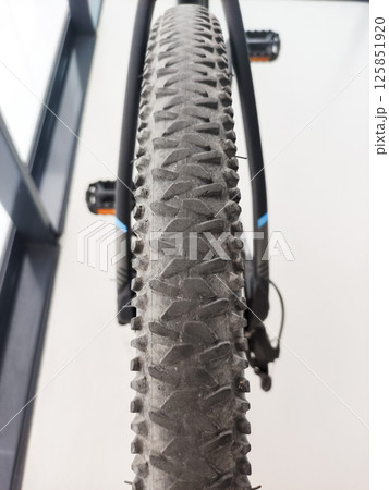 Close-up view of a rugged mountain bike tire showcasing intricate tread patterns and dirt, emphasizing durability and performance Close-up view of a rugged mountain bike tire showcasing intricate tread patterns and dirt, emphasizing durability and performance 125851920