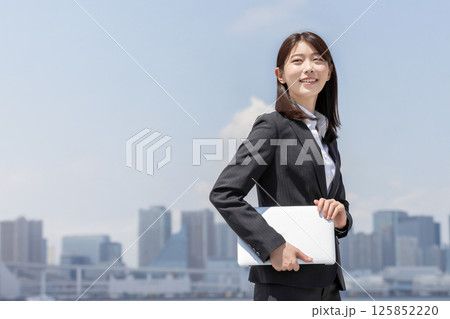 ノートパソコンを抱えるビジネスウーマン ノートパソコンを抱えるビジネスウーマン 125852220