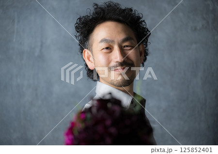 花束を贈る男性 誕生日母の日などのイベントのプレゼントのイメージ 花束を贈る男性 誕生日母の日などのイベントのプレゼントのイメージ 125852401