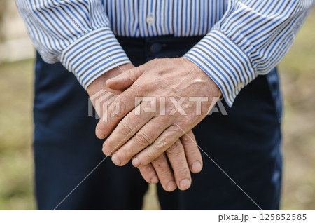 The worn hands of the pensioner are folded. The rough palms of an elderly man. The worn hands of the pensioner are folded. The rough palms of an elderly man. 125852585