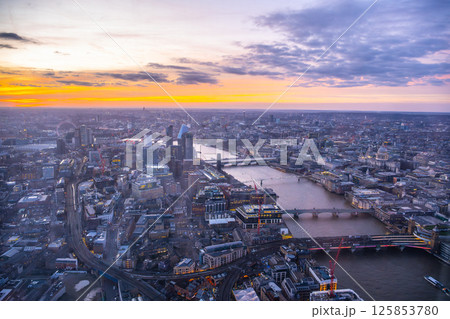 A breathtaking sunset over London, viewed from the Shard, casts vibrant colors across the skyline. The Thames River reflects the hues as the city winds down for the evening. A breathtaking sunset over London, viewed from the Shard, casts vibrant colors across the skyline. The Thames River reflects the hues as the city winds down for the evening. 125853780