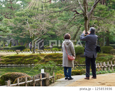 冬の兼六園の名所霞ヶ池と時雨亭を撮影する観光客の姿 125853936