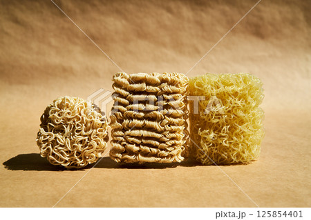 Various dry instant noodle blocks over brown background Various dry instant noodle blocks over brown background 125854401