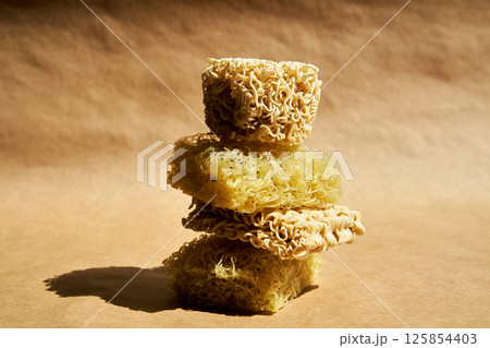 Creative food composition of ramen noodles over beige. 125854403