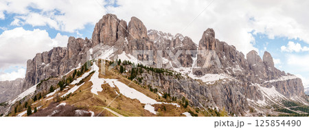 Majestic mountain range with snow patches and dramatic sky panoramic view near Valley of Funes at Dolomites, Italy 125854490