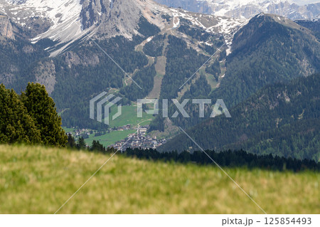 Scenic mountain valley landscape with snow-capped peaks and verdant forests in springtime near Valley of Funes at Dolomites, Italy 125854493