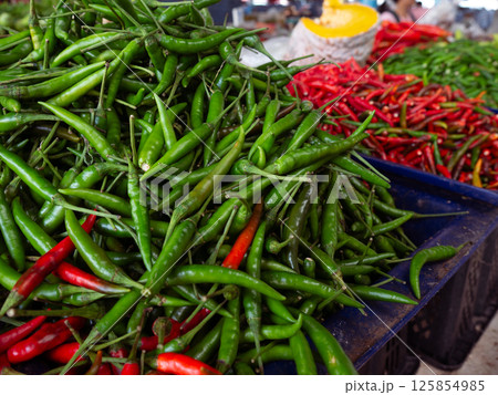 Fresh Organic green chilli peppers at local market. 125854985
